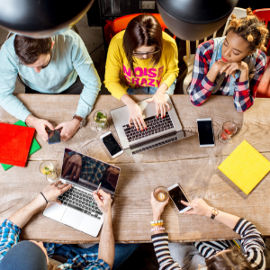 People sitting at table with electronics